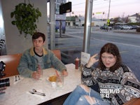 two people sitting at a table in a restaurant