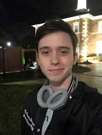 a young man wearing headphones in front of a building
