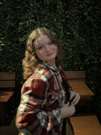 a girl in a plaid shirt posing for a photo