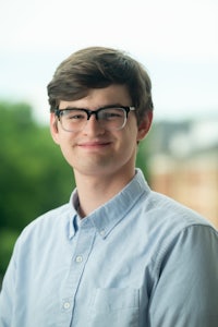 a young man wearing glasses and a blue shirt